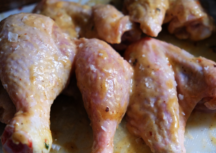Chicken Wings mit der Hälfte der Marinade bestreichen